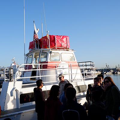 students at dock near boat